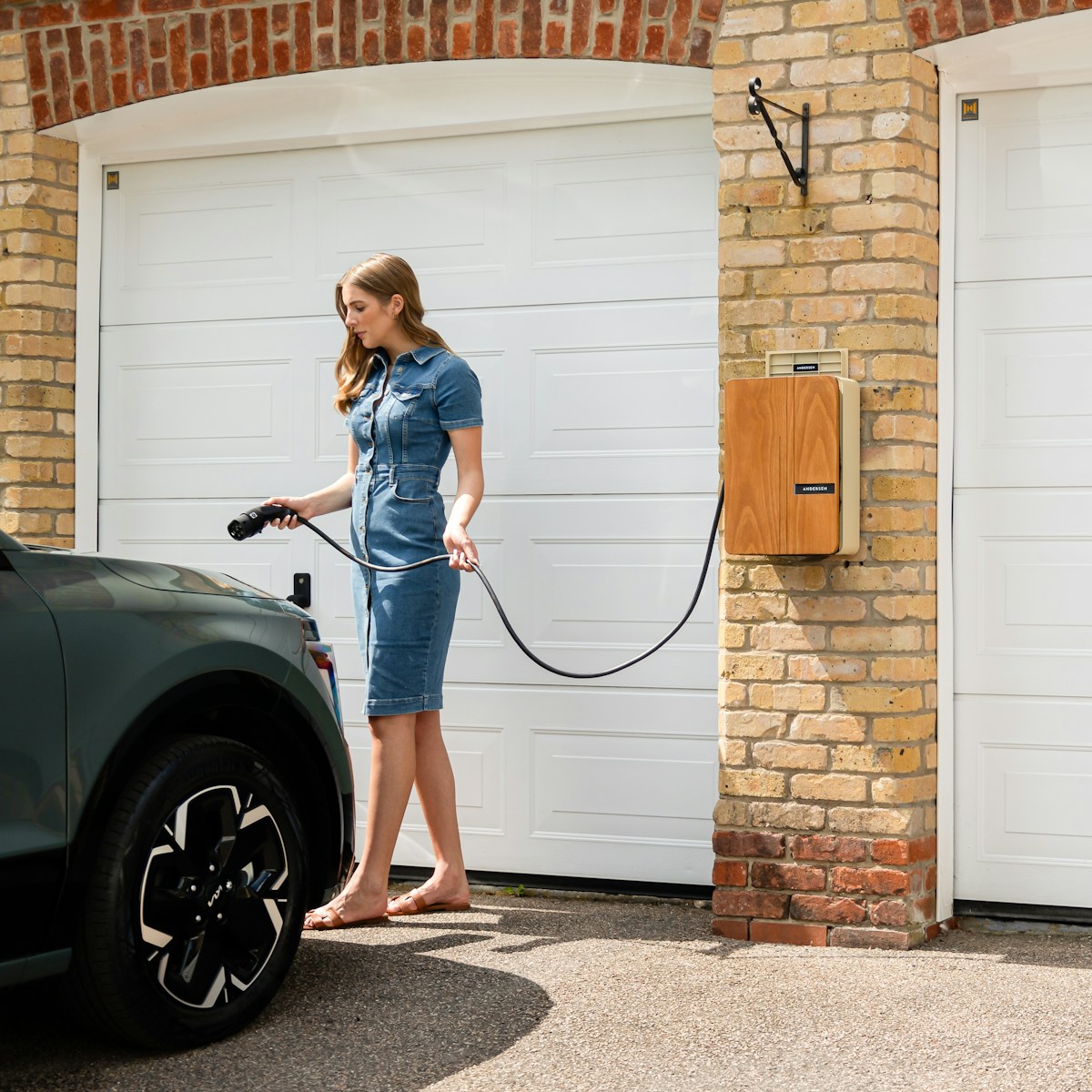A woman in a blue dress is washing a car